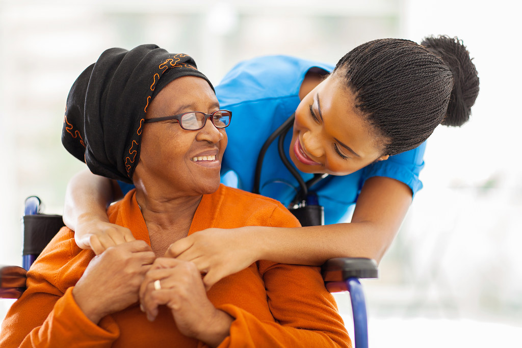 Professional caregiver in purple scrubs smiling warmly