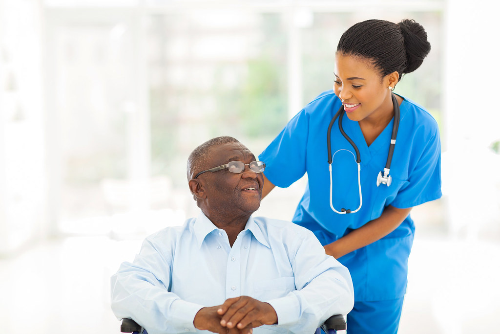 Compassionate caregiver holding hands with a smiling elderly woman