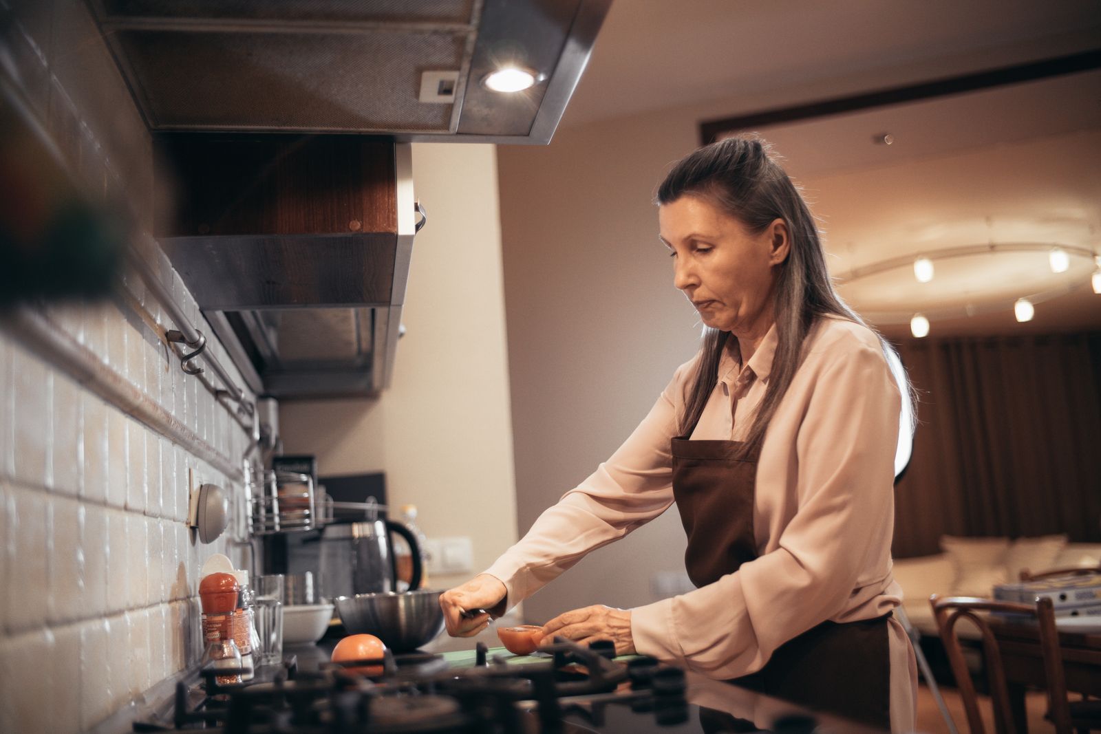 Caregiver making tea with elderly woman in a bright kitchen